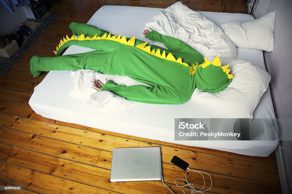 Uomo superato il mattino dopo serata in Costume del Dinosauro - Foto stock royalty-free di Postumi di una sbornia