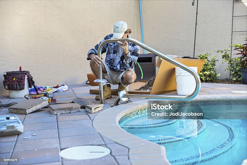 Safety: Installing a pool Hand rail installing a pool handrail Swimming Pool Stock Photo