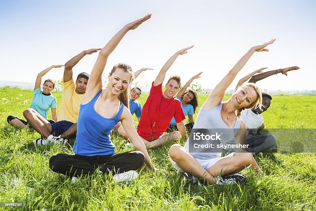 Grupo de pessoas fazendo exercícios de estiramento em campo. - Royalty-free Ao Ar Livre Foto de stock