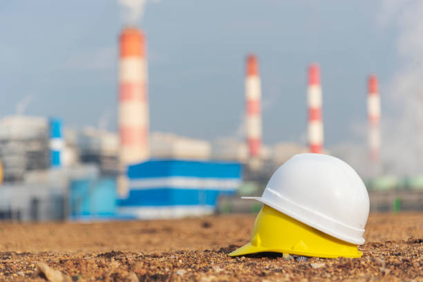 istock Worker Hard hat at Power stations manufacturing electrical industrial plant. Construction hard hat safety helmet Electric power building refinery engineering safety tools Lignite electricity chimneys 1699423955