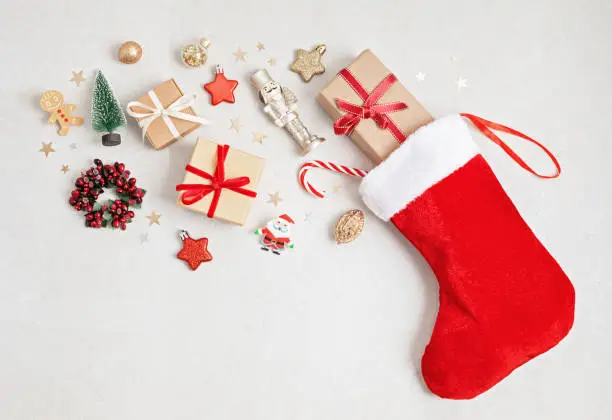 Red Christmas stocking with gifts and decoration. Traditional Xmas celebration concept