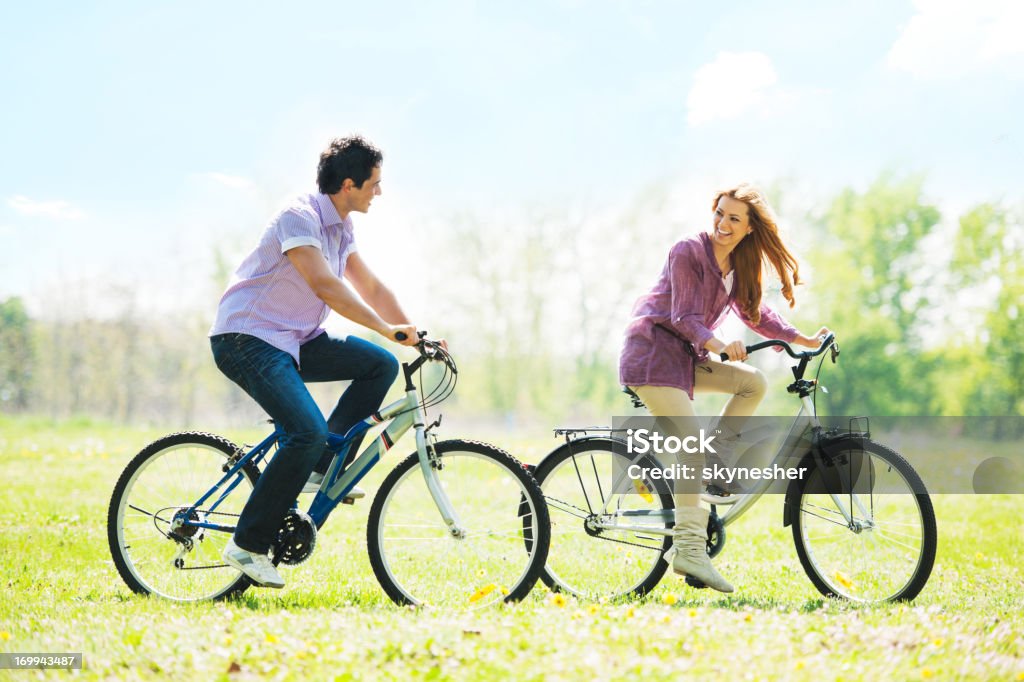 Hermosa pareja en bicicleta en el parque. - Foto de stock de Andar en bicicleta libre de derechos