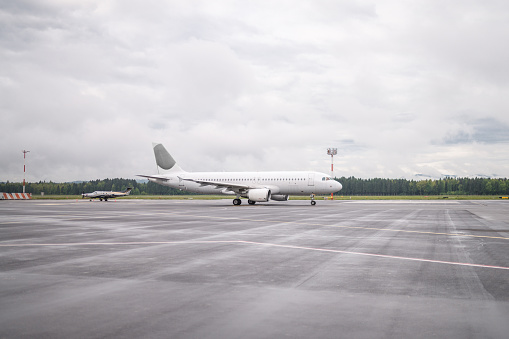 White commercial plane ready to depart on a cloudy and rainy day.