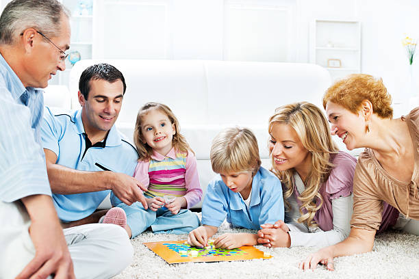 istock Cheerful extended family playing board game on the floor. 169943628