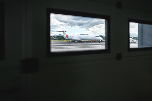 Through the window shot of an airplane parked at the airfield.