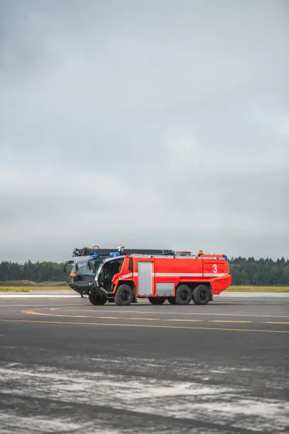Airports fire department firetrucks on an emergency drive at the airfield runway.