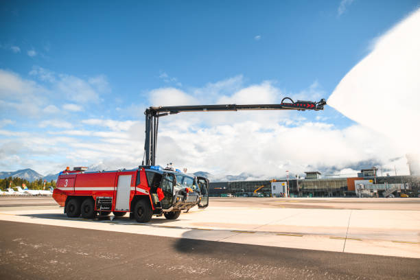 Firetruck Spraying Water At The Airport Runway Firetruck spraying water at the airport runway. fire truck at the airport stock pictures, royalty-free photos & images