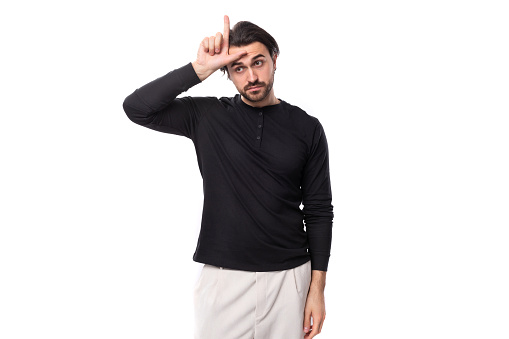 young tired handsome brunet european man in black sweatshirt on isolated white background.