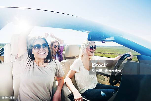 Three Women Enjoying In A Convertible Car Ride Stock Photo - Download Image Now - Adolescence, Adult, Arms Outstretched