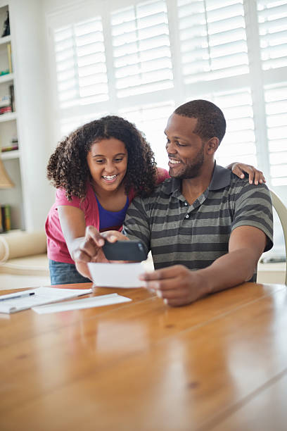 menina e o pai usando telefone inteligente com recibo de depósito - bank deposit slip imagens e fotografias de stock