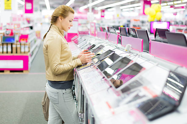 Woman buys a digital tablet at store Woman buys a digital tablet. electronics store stock pictures, royalty-free photos & images