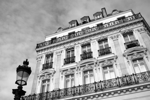 A black and white shot of a beautiful old bourgeois Haussmannian building on the Champs Elysees in Paris, France, housing luxury apartments or offices.