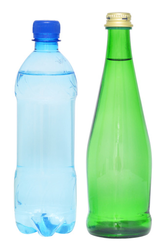 plastic and glass bottles of water on white background