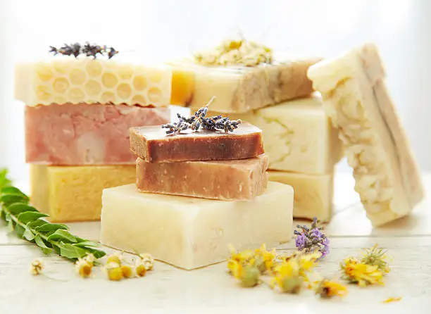 Stacks of homemade organic bars of soap with lavender and calendula flowers