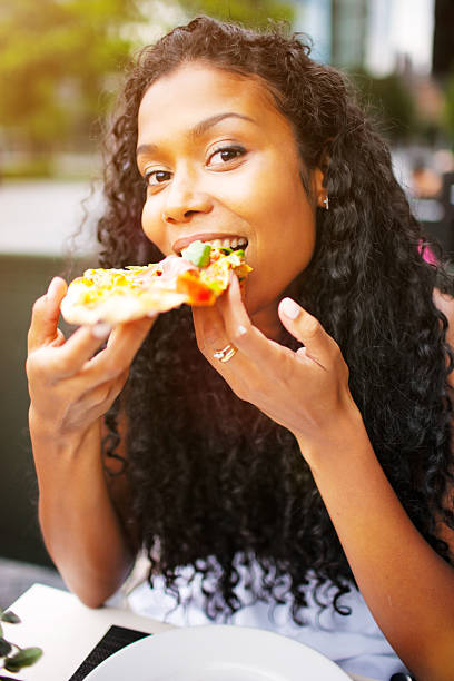 istock Happy Young Woman Eating Pizza 169947182