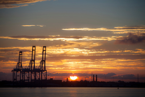 An incredible sunset backlights the shipping cranes at the port of Charleston, South Carolina