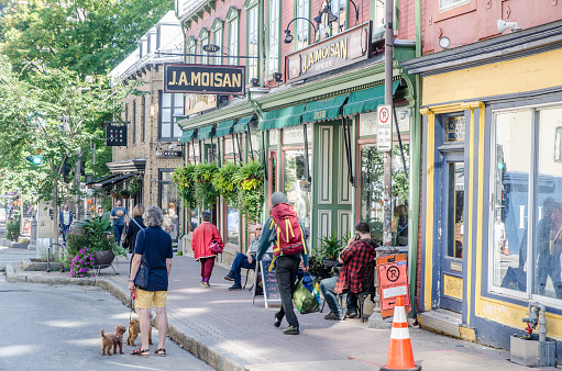 Facade of old grocery store with pedestrians during summer day in Old Quebec city