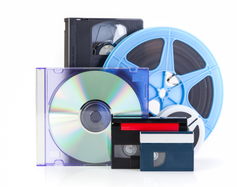 Video cassettes and film reels on white background with DVD, Concept for DVD transfer