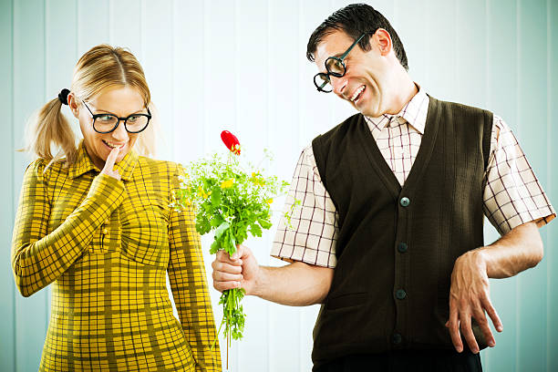 гик-человек, давая его подруга в день святого валентина подарок. - valentines day love nerd couple стоковые фото и изображения