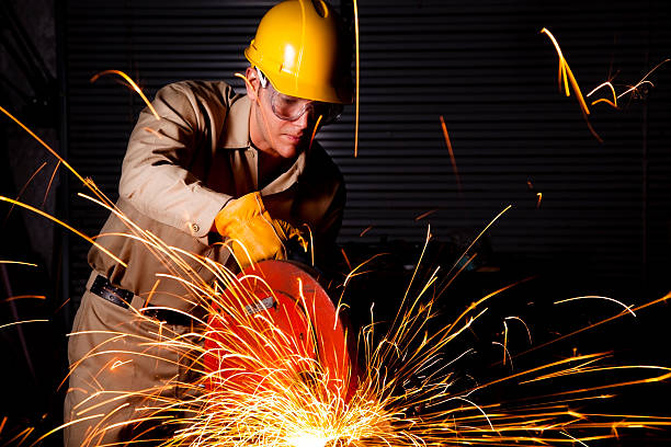 istock Man Grinding workshop wearing hardhat, safety goggles and gloves.  Sparks 169949165