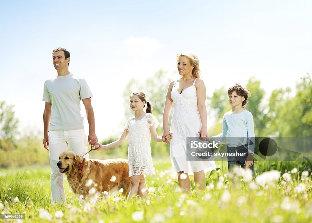 Famille heureuse à leur chien dans un parc. - Photo de Activité libre de droits