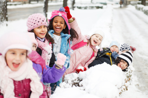 Beautiful children are enjoying in the snow.   