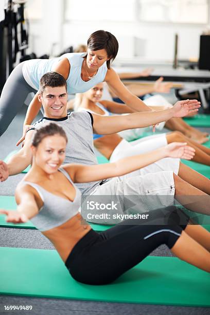 Allenatore Aiutando Persone Con Pilates Esercizi - Fotografie stock e altre immagini di Abbigliamento sportivo - Abbigliamento sportivo, Adulto, Aerobica