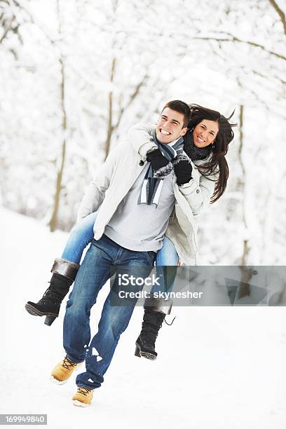 Un Belluomo Dando Alla Sua Fidanzata Un Piggyback Giro - Fotografie stock e altre immagini di Abbigliamento