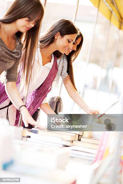 Młode Kobiety Kupno Książki - zdjęcia stockowe i więcej obrazów Kobiety - Kobiety, Książka, Kupować