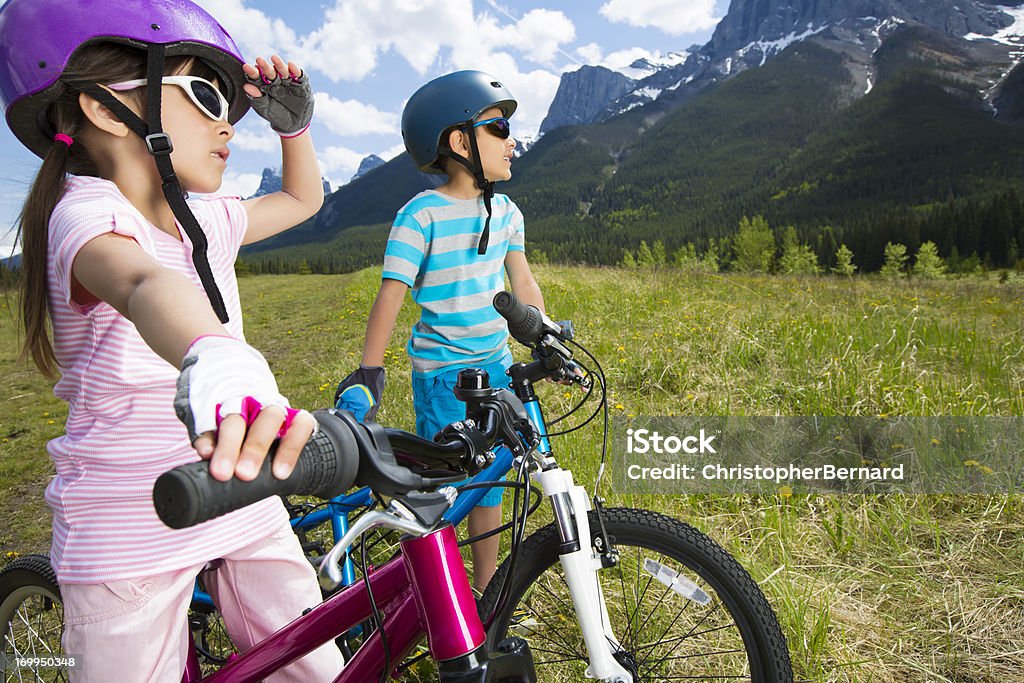 Irmãos colocar em suas bicicletas desfrutando a vista - Foto de stock de 6-7 Anos royalty-free