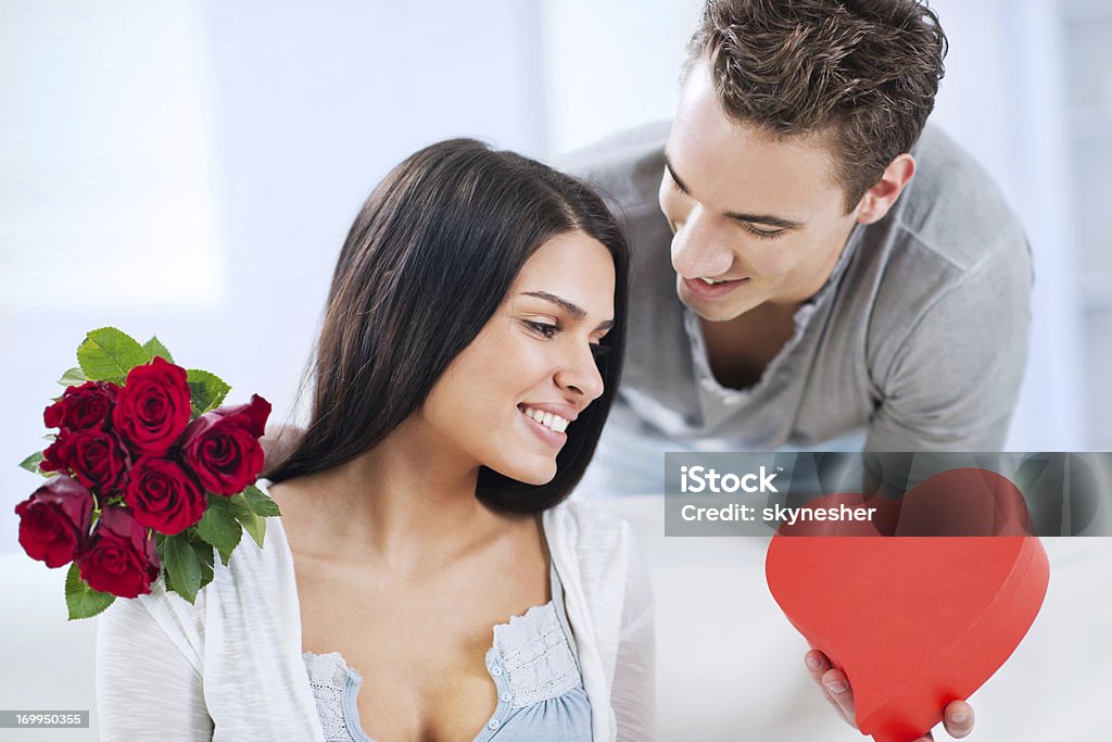 Sorrindo jovem dando buquê de rosas para sua namorada - Foto de stock de Adulto royalty-free