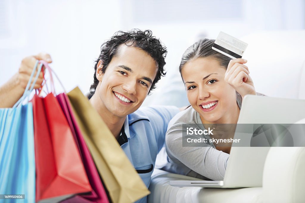 Jeune couple avec ordinateur portable, achats et de carte de crédit - Photo de Achat à domicile libre de droits