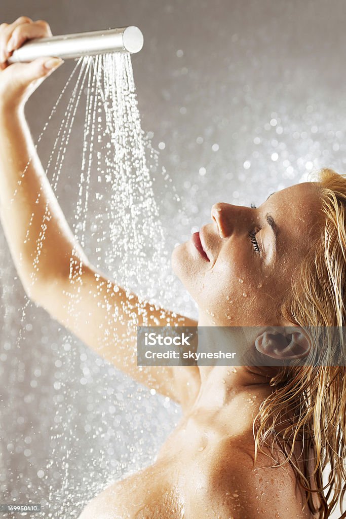 Jovem mulher tomando banho com um chuveiro. - Foto de stock de Chuveiro - Instalação doméstica royalty-free