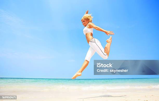 Młoda Atrakcyjna Kobieta Skoki Na Plaży - zdjęcia stockowe i więcej obrazów Aktywny tryb życia - Aktywny tryb życia, Biały, Blond włosy