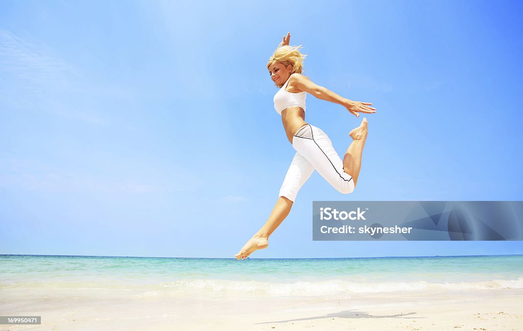 Jovem bela mulher pulando na praia. - Foto de stock de Adulto royalty-free