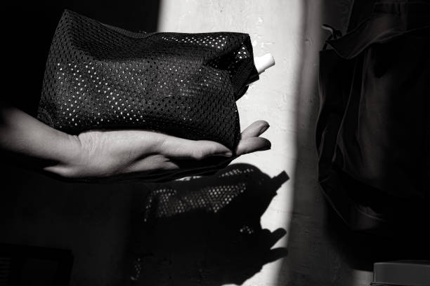istock hand holding a pouch containing skincare. 1699509986