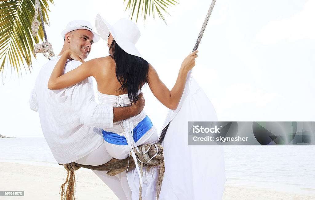 Piękna para Huśtać się na plaży - Zbiór zdjęć royalty-free (Biały)