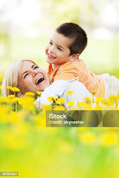 Giovane Madre E Figlio Giocando Nel Campo Di Dandelions - Fotografie stock e altre immagini di Abbracciare una persona