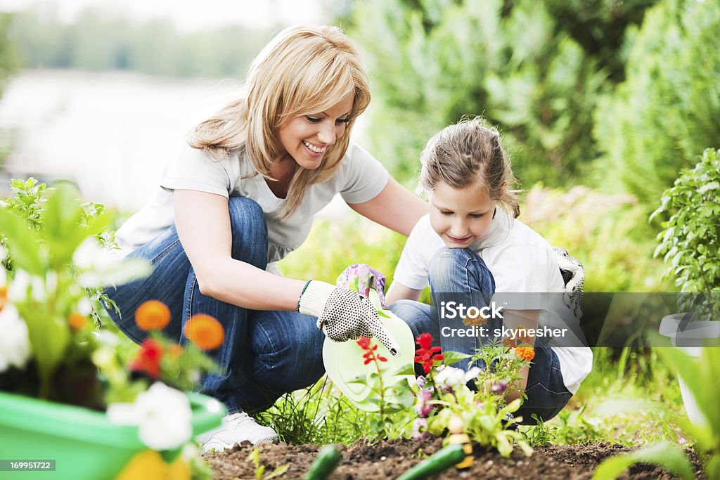 Madre e figlia piantando fiori insieme - Foto stock royalty-free di Primavera