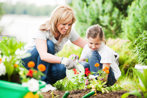 Front view of a mother and her daughter gardening.  