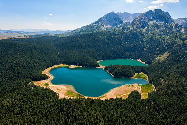 Magnificent Durmitor Aerial photo of the glacial lake framed with the high forest, located below Durmitor mountain massif, Montenegro, Europe. Black Lake (Crno jezero) is the most popular tourist attraction of Durmitor area, consists of two smaller lakes, Large lake (Veliko jezero) and Small lake (Malo jezero). National Park Durmitor was listed by UNESCO as a World Heritage. Photo was taken from the helicopter. durmitor national park photos stock pictures, royalty-free photos & images