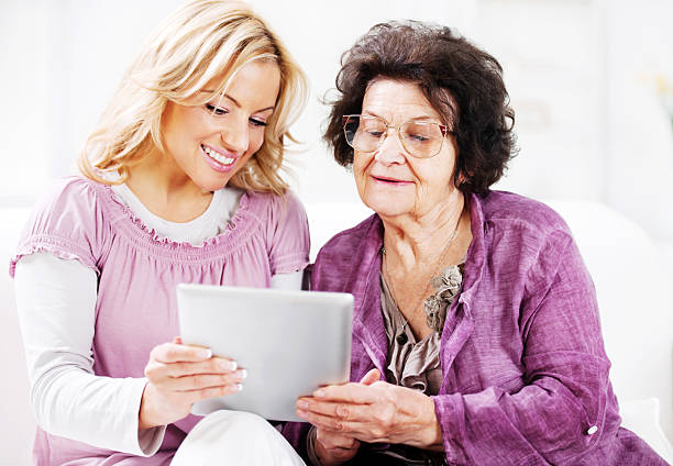 istock Daughter teaching her senior mother to use touchpad. 169952048