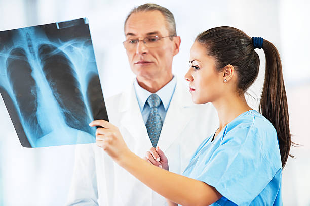 médico examinar una imagen radiográfica. - x ray image radiologist examining using voice fotografías e imágenes de stock