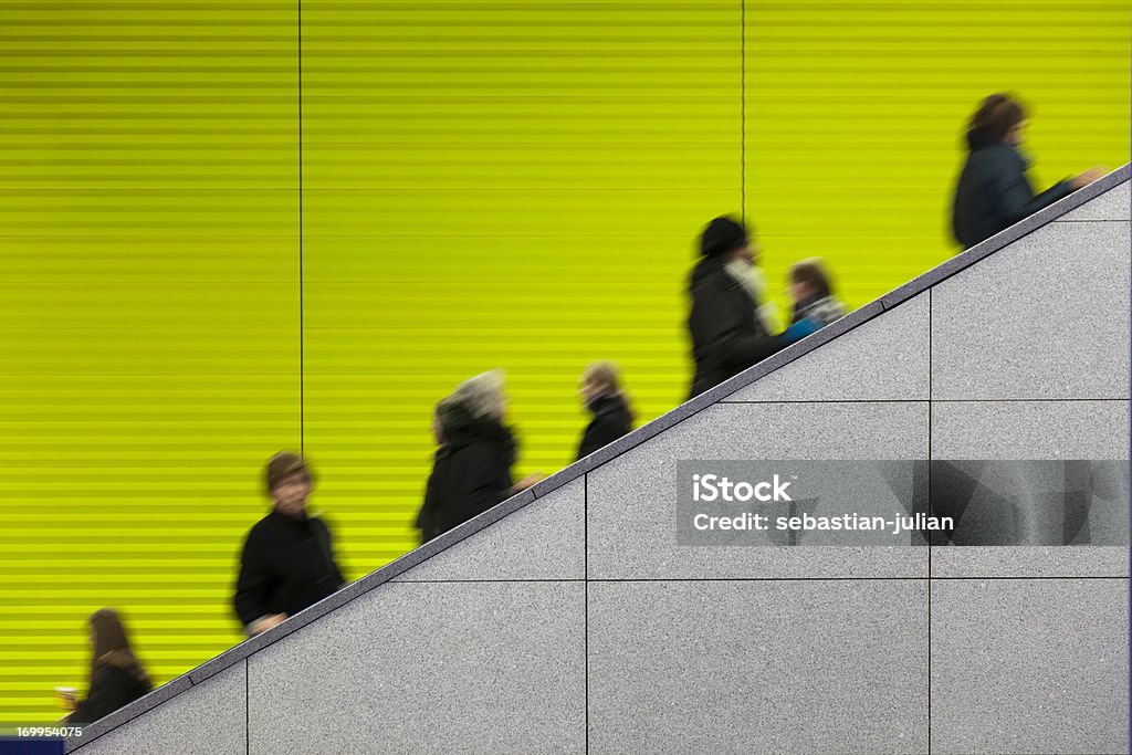 Civilians riding an escalator with a green screen background motion blurred commuters at modern underground platform - grey marble in front - copy space - camera canon 5D mark II - unsharped RAW - adobe colorspace People Stock Photo
