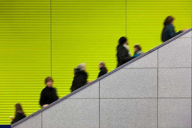 Civilians riding an escalator with a green screen background stock photo