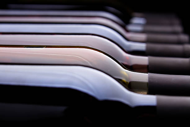 Row of Wine Bottles Shallow focus abstract shot of a series of wine bottles with different kinds of wine laying flat wine bottle photos stock pictures, royalty-free photos & images