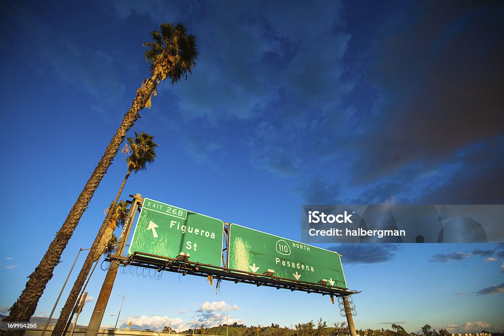 Znak autostrady w Los Angeles, palmami i głębokie błękitne niebo - Zbiór zdjęć royalty-free (Droga wielopasmowa)