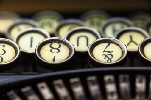 Macro detail photograph of a vintage typewriter. Focus is on number key row.