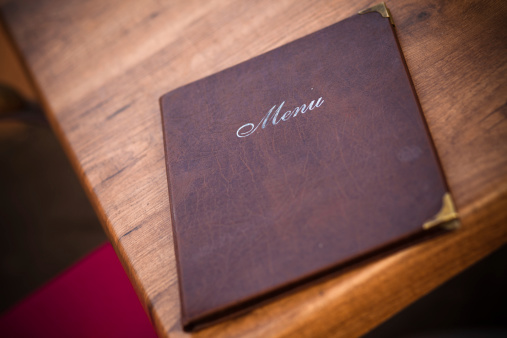 A beautifully-worn leather-bound menu at a European cafe in Prague, Czech Republic