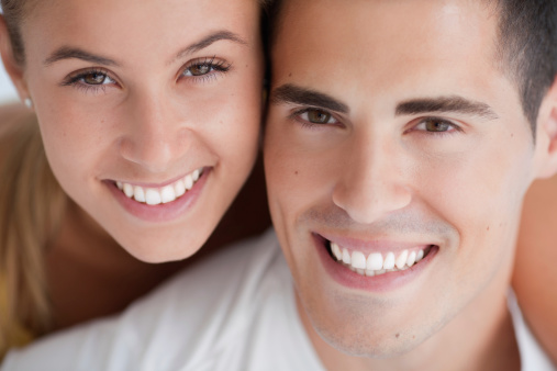 Close up of happy young couple smiling and looking at camera..